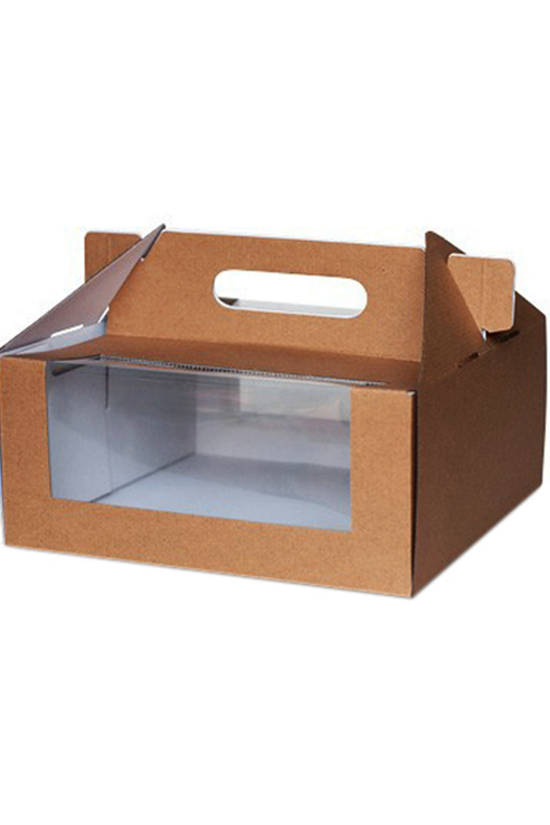 A corrugated cardboard cake box with a clear front window, brown body, and a handle on top.